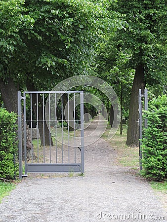 Treelined path and open gate Stock Photo