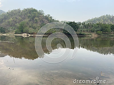 Trees and hills reflecting in a lake Stock Photo