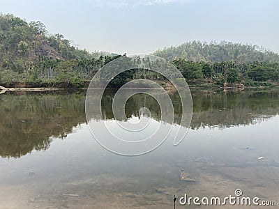 Trees and hills reflecting in a lake Stock Photo