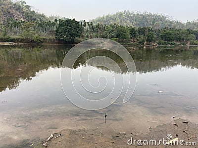 Trees and hills reflecting in a lake Stock Photo