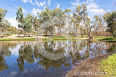 Trees and people reflected on a water pond. Perfect symmetry. Ellery Creek Big Hole, West Macdonnell ranges, Northern Territory NT Stock Photo