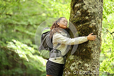 Trekker embracing a tree in a forest Stock Photo