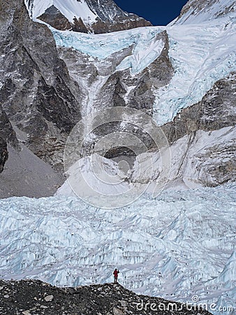 Trekker Standing in Front of Khumbu Glacier in Nepal Stock Photo
