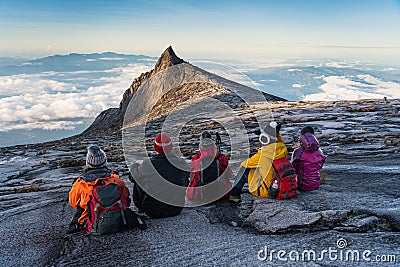 Trekkers sitting on rock looking to South peak, Kinabalu national park in Borneo island, Sabah state in Malaysia Editorial Stock Photo