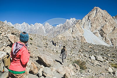 Trekkers walking along the track in Passu, Pakistan. Editorial Stock Photo