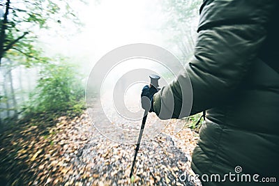 Trekking Pole. Adventure. Exploring. People Active. Closeup of woman hikers hand. Misty nature Stock Photo