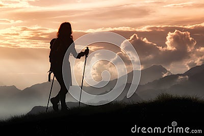 Trekking in solitude among the mountains. Silhouette of a girl Stock Photo