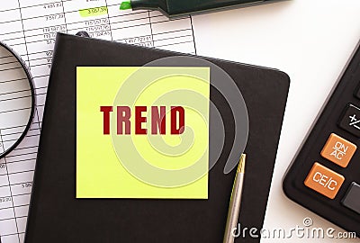 TREND text on a sticker on your desktop. Diary, calculator and pen. Stock Photo