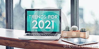 Trends for 2021 in laptop computer screen with icon floating on tablet on wood stood table in at window with blur background, Stock Photo