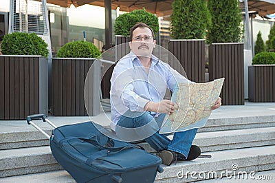 Trendy adult man in the town with touristic map outdoors. Stock Photo