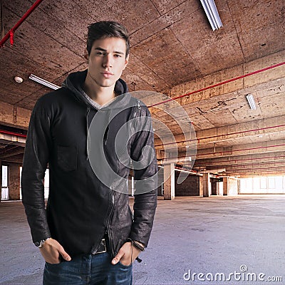 Trendy attractive young man standing in empty warehouse Stock Photo