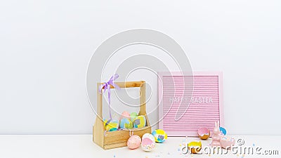 Trendy colorful composition with hand painted Easter eggs, confetti, Easter bunny. Board with Happy Easter greetings. Stock Photo