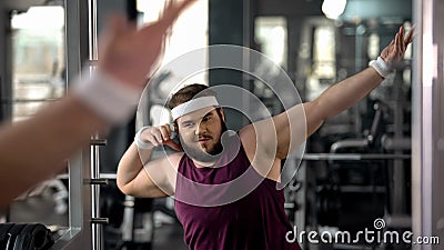 Trendy fat man showing dab move at mirror, satisfied with weight loss results Stock Photo