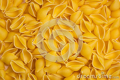 Trendy flat view closeup yellow macaroni. Conchiglie. Top view, flat lay. Nature concept. Texture background, pattern. Restaurant Stock Photo