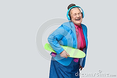 Trendy funny joyful grandmother in colorful casual style with bl Stock Photo