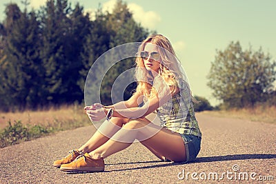 Trendy Hipster Girl Sitting on the Road Stock Photo