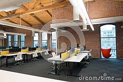 Trendy modern open concept loft office space with big windows, natural light and a layout to encourage collaboration Stock Photo