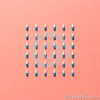 Trendy pattern made with Pharmaceutical medicine pills, tablets and capsules on bright light coral background Stock Photo