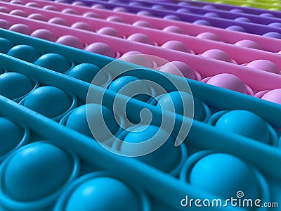 Trendy popular silicone colorful anti stress pop it toy . Close up. Someone push sensory popit. Trendy hype theme from Stock Photo