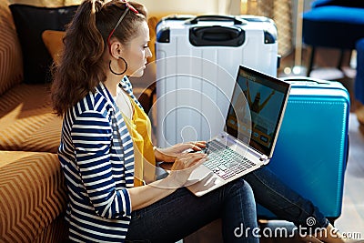 Trendy solo traveller woman booking tickets on laptop Stock Photo