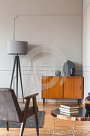 Trendy vintage armchair in stylish scandinavian living room interior with grey wall Stock Photo