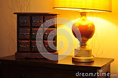 Trendy wallpaper texture. Cozy interior home decor. Elegant wooden dresser furniture. Decorative luxury table lamp style Stock Photo