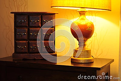 Trendy wallpaper texture. Cozy interior home decor. Elegant wooden dresser furniture. Decorative luxury table lamp style Stock Photo