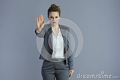 trendy woman worker showing stop gesture isolated on grey Stock Photo