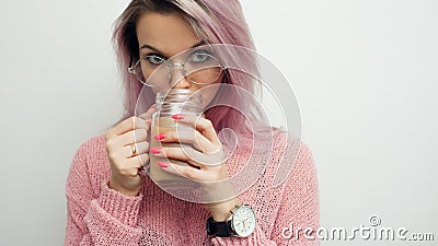 Trendy young woman in glasses drinking coffee milkshake. Stock Photo