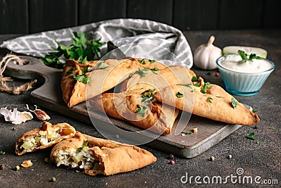 Triangle meat or chicken pie with potatoes, sour cream, onions, garlic and spices Stock Photo