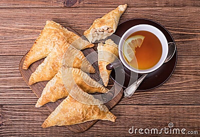 Triangle meat pies with cup of tea . Stock Photo