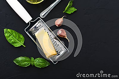 Triangle piece of parmesan cheese on a grater,garlic,green basil. Food ingredients for making pasta, spaghetti, bruschetta, pizza Stock Photo