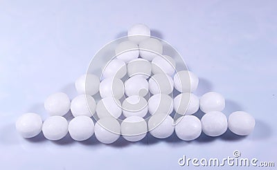 A triangle shaped pile of white naphthalene balls. Stock Photo