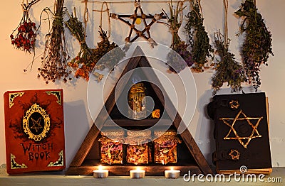 Triangle shelf with witch books, pentagram and dry flowers and herbs Stock Photo