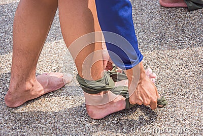 Triangular bandage improvies fix right ankle dislocate Stock Photo