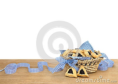 Triangular cookies with poppy seeds hamantasch or aman ears and blue ribbon on wooden table on white background Stock Photo