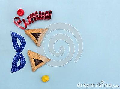 Triangular cookies with poppy seeds hamantasch or aman ears , candy, glitter mask, serpentine for jewish holiday of purim Stock Photo