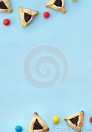 Triangular cookies with poppy seeds hamantasch or aman ears , colored candy for jewish holiday of purim celebration on blue Stock Photo