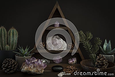 Triangular Crystal Shelf with Plants Foliage Gems and Jewellery on a Wooden Surface Stock Photo