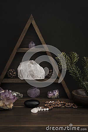 Triangular Crystal Shelf on a Wooden Surface with Jewellery and Foliage Stock Photo