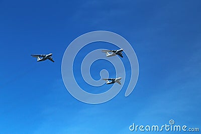 A triangular formation of a group of three russian military fighter bomber jet planes flying high in blue sky during Vicotry Day Editorial Stock Photo