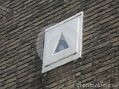 Triangular little window in a brown brick wall Stock Photo