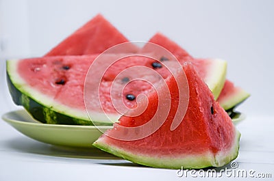 Triangular piece of watermelon and a plate of watermelon slices Stock Photo