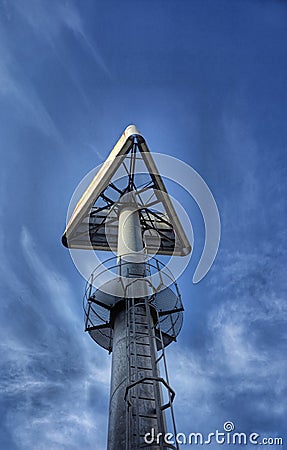 Triangular sign on a high steel pole Stock Photo