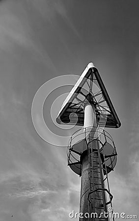 Triangular sign on a high steel pole Stock Photo