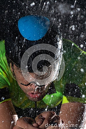 A triathlete braving the rain as he cycles through the night, preparing himself for the upcoming marathon. The blurred Stock Photo