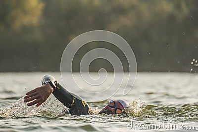 Triathletes swim on start of the Ironman triathlon competition Editorial Stock Photo