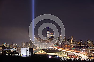 The 9/11 tribute lights seen next to One World Trade, with car light trails from Interstate 278 heading towards NYC Editorial Stock Photo