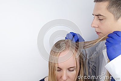 A trichologist examines a girl with oily hair. Problematic scalp and increased secretion of the sebaceous glands. Hair care. Oily Stock Photo