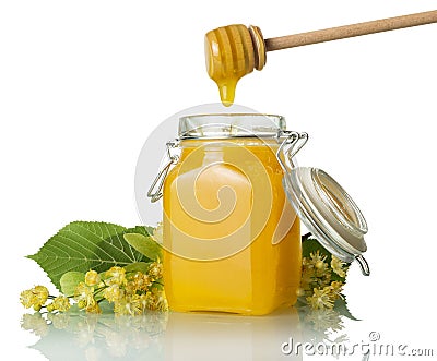 Trickle of golden honey flows from beater into jar, isolated on white Stock Photo